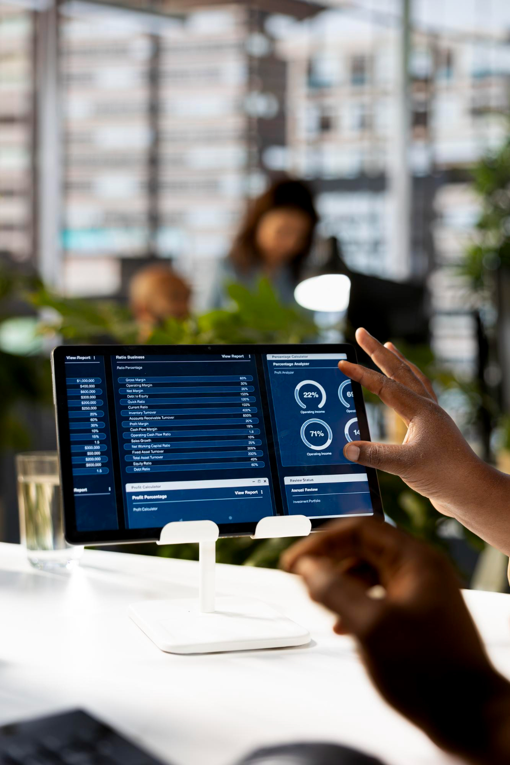 Colleagues reviewing an operations dashboard on a tablet in a bright meeting room.